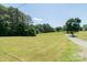 View of the property featuring a large green lawn and driveway leading to the house at 28782 Canton Rd # A, Albemarle, NC 28001