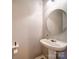 Clean, white half-bathroom featuring a pedestal sink, round mirror, and modern fixtures at 3055 Golden Dale Ln # 104, Charlotte, NC 28262