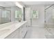 Bright bathroom with double sinks, quartz countertop, glass shower, and plenty of natural light at 3135 Everly Enclave Way, Charlotte, NC 28210