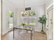 Charming dining area with glass table, stylish chandelier, and lots of natural light from backyard at 3135 Everly Enclave Way, Charlotte, NC 28210