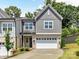 Charming two-story home with gray siding, brick accents, a two-car garage, and a well-manicured front yard at 3135 Everly Enclave Way, Charlotte, NC 28210