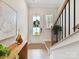 Bright foyer featuring hardwood floors, staircase with black railings, and stylish decor at 3135 Everly Enclave Way, Charlotte, NC 28210