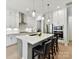 Well-equipped kitchen with white cabinetry, stainless steel appliances, and spacious island with bar stools at 3135 Everly Enclave Way, Charlotte, NC 28210