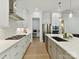Modern kitchen with stainless steel appliances, white cabinetry, and a spacious island with quartz countertops at 3135 Everly Enclave Way, Charlotte, NC 28210