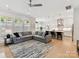 Open-concept living room with large sectional sofa, modern ceiling fan, and views into the kitchen at 3135 Everly Enclave Way, Charlotte, NC 28210