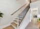Wooden staircase with modern iron railing, allowing natural light to flow through the home at 3135 Everly Enclave Way, Charlotte, NC 28210