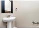 Powder room featuring a pedestal sink, decorative mirror, and neutral wall color at 3251 Park South Station Blvd, Charlotte, NC 28210