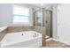 Bathroom showcasing separate tub and shower with tile surround, plus a window at 3251 Park South Station Blvd, Charlotte, NC 28210