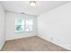 Bedroom with carpet flooring, neutral walls, and a large window overlooking the front yard at 3251 Park South Station Blvd, Charlotte, NC 28210