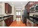 Well-lit kitchen with dark wood cabinets, granite counters, stainless appliances, and hardwood floors at 3251 Park South Station Blvd, Charlotte, NC 28210