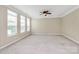 Expansive living area featuring neutral walls, carpeting, large windows, and a ceiling fan at 3251 Park South Station Blvd, Charlotte, NC 28210