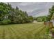 Spacious backyard with lush green grass, storage sheds, and mature trees at 330 Kilmer Ln, Mooresville, NC 28115