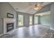 Bright living room featuring a fireplace, ceiling fan, and multiple windows at 330 Kilmer Ln, Mooresville, NC 28115