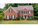 Charming red brick home featuring black shutters, lush landscaping, and a well-maintained lawn at 4066 Belle Meade Cir, Belmont, NC 28012
