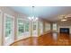 Sunlit living room with hardwood floors, fireplace, and large windows overlooking the backyard at 4066 Belle Meade Cir, Belmont, NC 28012