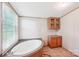 This bathroom features an oval soaking tub with tile flooring and cabinetry, perfect for relaxation at 4122 Canal Rd, Marshville, NC 28103
