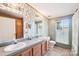 Bathroom featuring double sinks, a large mirror, and wallpaper with natural light from the window at 4122 Canal Rd, Marshville, NC 28103