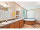 Bright bathroom featuring a double vanity, tile floors, a soaking tub, and a separate shower at 4122 Canal Rd, Marshville, NC 28103