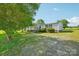 View of the front yard and charming home nestled among mature shade trees at 4122 Canal Rd, Marshville, NC 28103