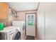 Functional laundry room with modern washer and dryer, shelving, and convenient access to the outdoors at 4122 Canal Rd, Marshville, NC 28103