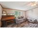 Bright living room featuring a comfortable couch, a piano, and large windows at 4122 Canal Rd, Marshville, NC 28103
