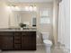 Bathroom featuring double vanity with granite countertops, a large mirror, and a toilet at 415 Tayberry Ln, Fort Mill, SC 29715