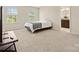 Bright bedroom featuring neutral carpeting, two windows, and doorway to the bathroom at 415 Tayberry Ln, Fort Mill, SC 29715