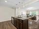 Modern kitchen island with granite countertops and stainless steel appliances overlooks living space at 415 Tayberry Ln, Fort Mill, SC 29715