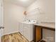 Laundry room with modern washer and dryer, shelving, and laminate flooring at 415 Tayberry Ln, Fort Mill, SC 29715