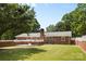 Brick home featuring a spacious backyard with a patio and well-maintained lawn at 4600 Beatties Ford Rd, Charlotte, NC 28216