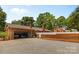 This fenced backyard features a brick fence, well maintained landscaping and a gravel driveway, plus a detached garage at 4600 Beatties Ford Rd, Charlotte, NC 28216