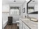 This bathroom offers a single vanity with marble counters, framed mirrors, and modern fixtures plus a window to allow natural light at 4600 Beatties Ford Rd, Charlotte, NC 28216
