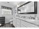 This bathroom offers a dual vanity with marble counters, framed mirrors, and modern fixtures plus a window to allow natural light at 4600 Beatties Ford Rd, Charlotte, NC 28216
