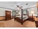 This bedroom features a four poster bed, ceiling fan, a wooden cabinet and matching furnishings plus a soothing color scheme at 4600 Beatties Ford Rd, Charlotte, NC 28216