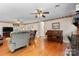 Spacious living room featuring a classic piano, hardwood floors, and a ceiling fan at 4600 Beatties Ford Rd, Charlotte, NC 28216