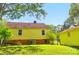 Backyard view of yellow house and garage with brick foundation, green grass and partial shade at 509 S Clay St, Gastonia, NC 28052