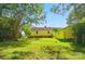 View of the backyard showing the yellow house and yellow detached garage with a lawn at 509 S Clay St, Gastonia, NC 28052