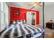 A modern bedroom features a bed with a black and white comforter and a red accent wall at 509 S Clay St, Gastonia, NC 28052