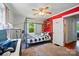 A modern bedroom features a bed with a black and white comforter and a red accent wall at 509 S Clay St, Gastonia, NC 28052