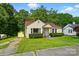 Charming yellow bungalow with red roof, well-kept lawn, and detached garage, perfect for storage and parking at 509 S Clay St, Gastonia, NC 28052