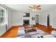 Bright living room features a beautiful stone fireplace, ceiling fan, and gleaming wood floors at 509 S Clay St, Gastonia, NC 28052