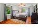 Comfortable bedroom featuring wood floors, windows, and a wooden bed frame at 509 S Clay St, Gastonia, NC 28052