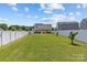 Large, grassy backyard with a white privacy fence and manicured landscaping at 5325 Merwyn Ave, Charlotte, NC 28215