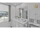 Bathroom with double sinks, white cabinets, and a large mirror over the vanity at 5325 Merwyn Ave, Charlotte, NC 28215