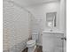 Bright bathroom features a toilet, vanity, mirror, and a shower with a patterned curtain at 5325 Merwyn Ave, Charlotte, NC 28215