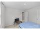 Neutral bedroom with a blue bed, TV, and doorway at 5325 Merwyn Ave, Charlotte, NC 28215