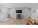 Cozy living room showcasing a mounted TV, adjacent staircase, and an open layout into the kitchen at 5325 Merwyn Ave, Charlotte, NC 28215