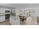 A modern living room with wood floors, a dining table, an island, and stainless steel kitchen appliances at 5325 Merwyn Ave, Charlotte, NC 28215
