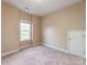 Bedroom with neutral carpet, a window, and a closet door, offering comfort and functionality at 533 Montgrove Nw Pl, Concord, NC 28027