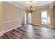 Elegant dining room with gray wood flooring, a chandelier, and natural light from two large windows at 533 Montgrove Nw Pl, Concord, NC 28027